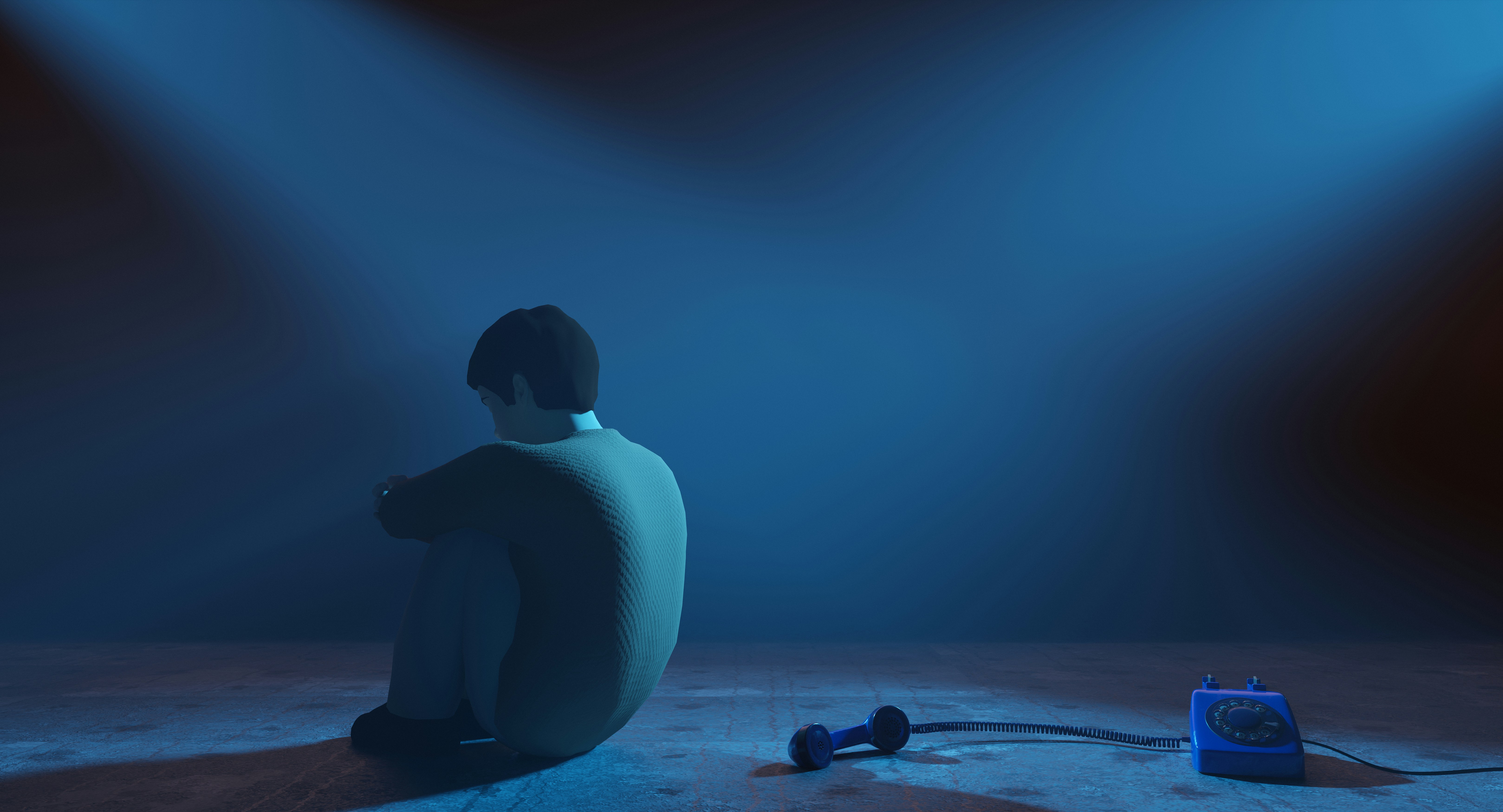 A person sits with a phone on the floor.