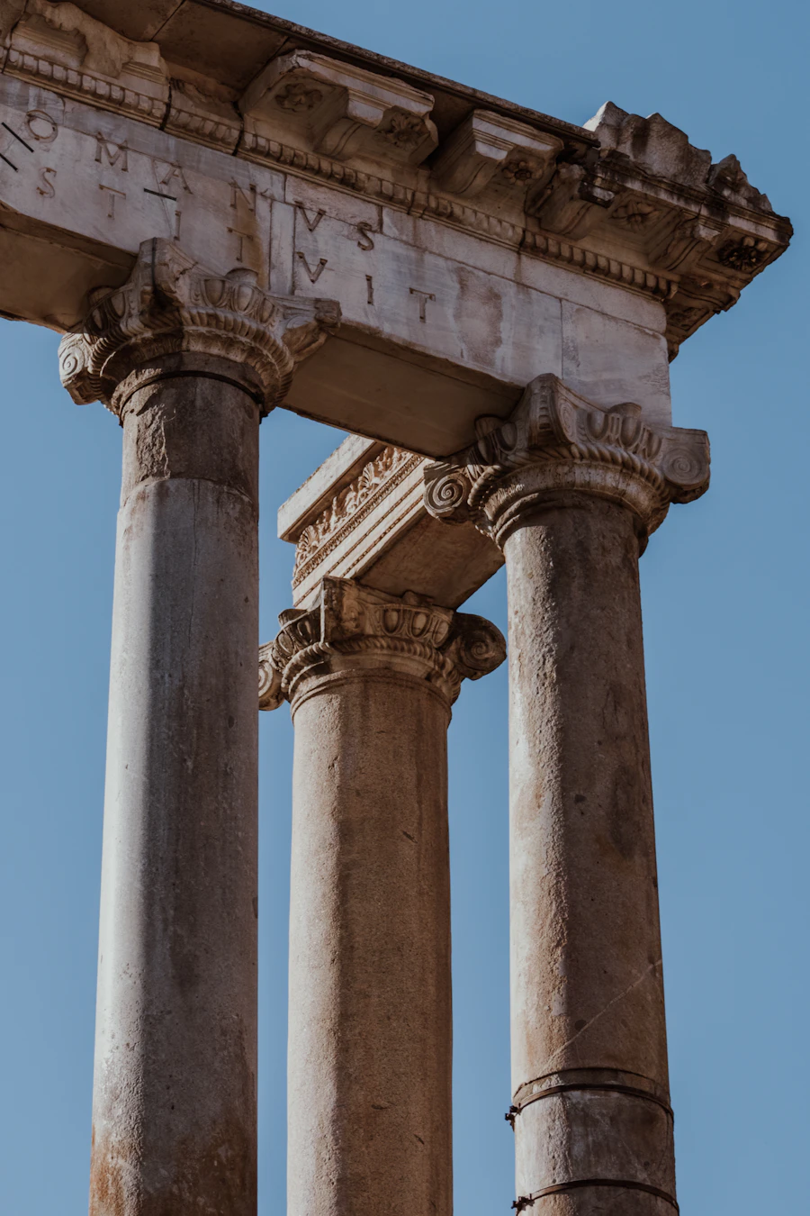 Ancient Roman columns at the Roman Forum against a bright blue sky, echoing the structure and steady counsel theme carried across the site