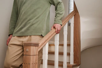 A person walks downstairs, holding the handrail