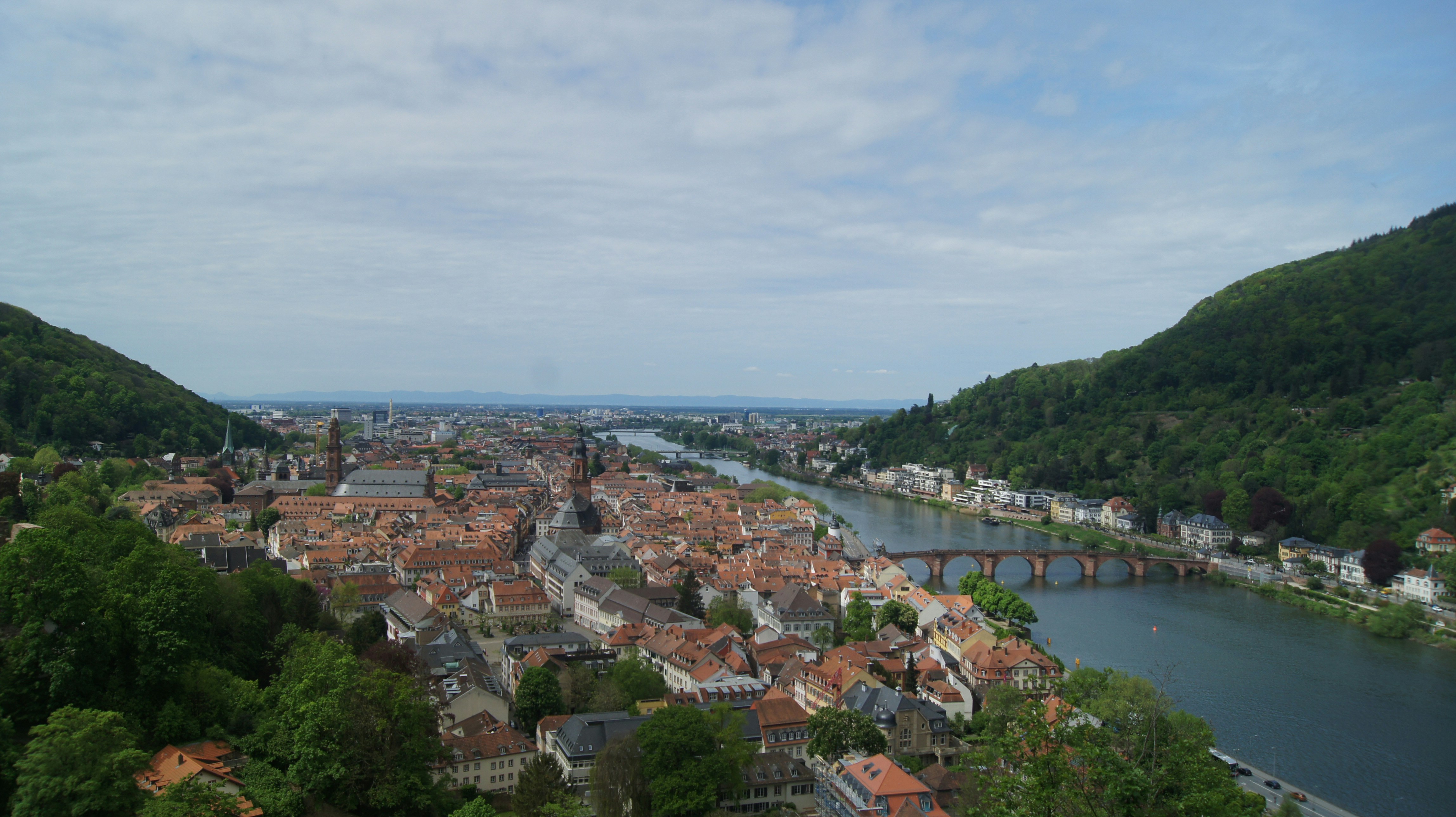 A beautiful cityscape sits between two green hills.