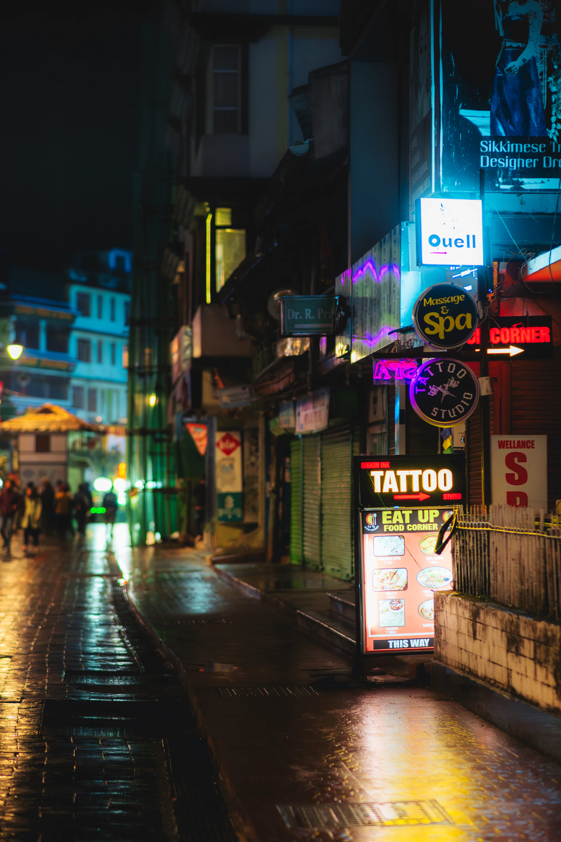 Night scene of a wet city street with neon signs