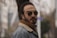 Man with sunglasses looks directly at the camera.
