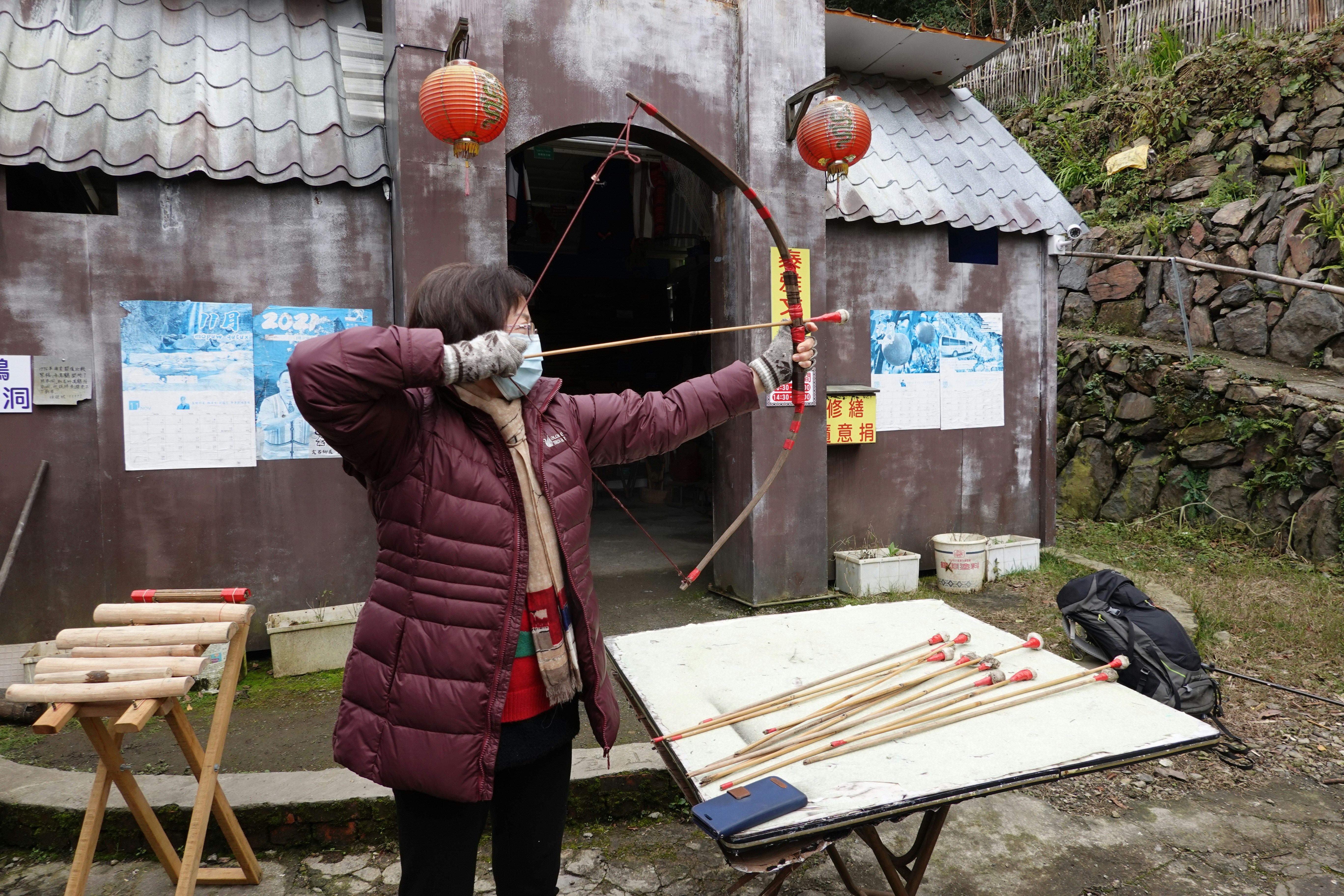 Woman aims a bow and arrow at an archery range.