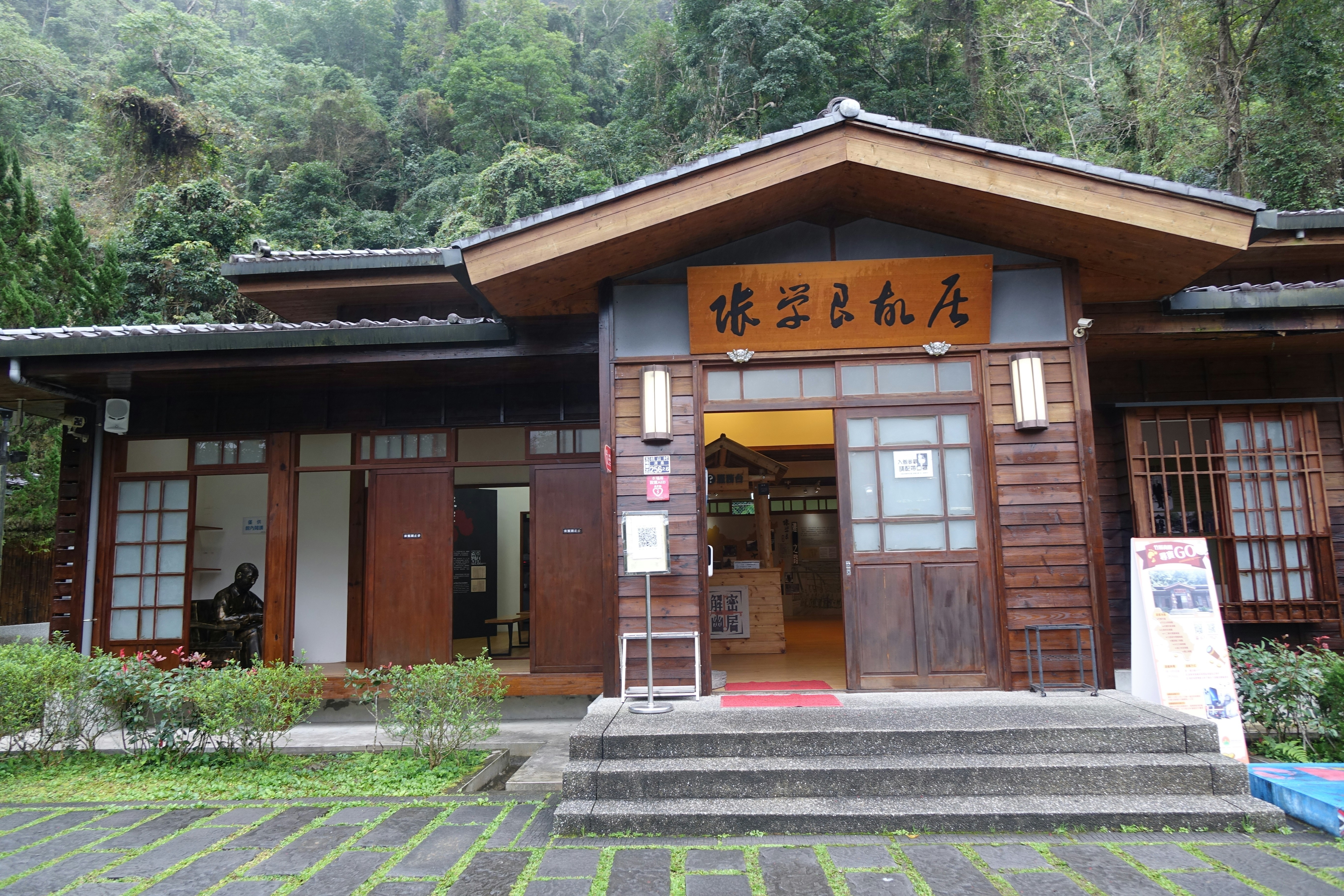 A wooden building with japanese writing on top.