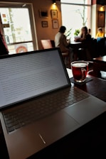 Laptop with a drink in a coffee shop.
