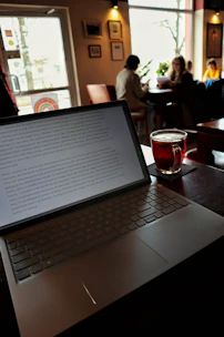 Laptop with a drink in a coffee shop.