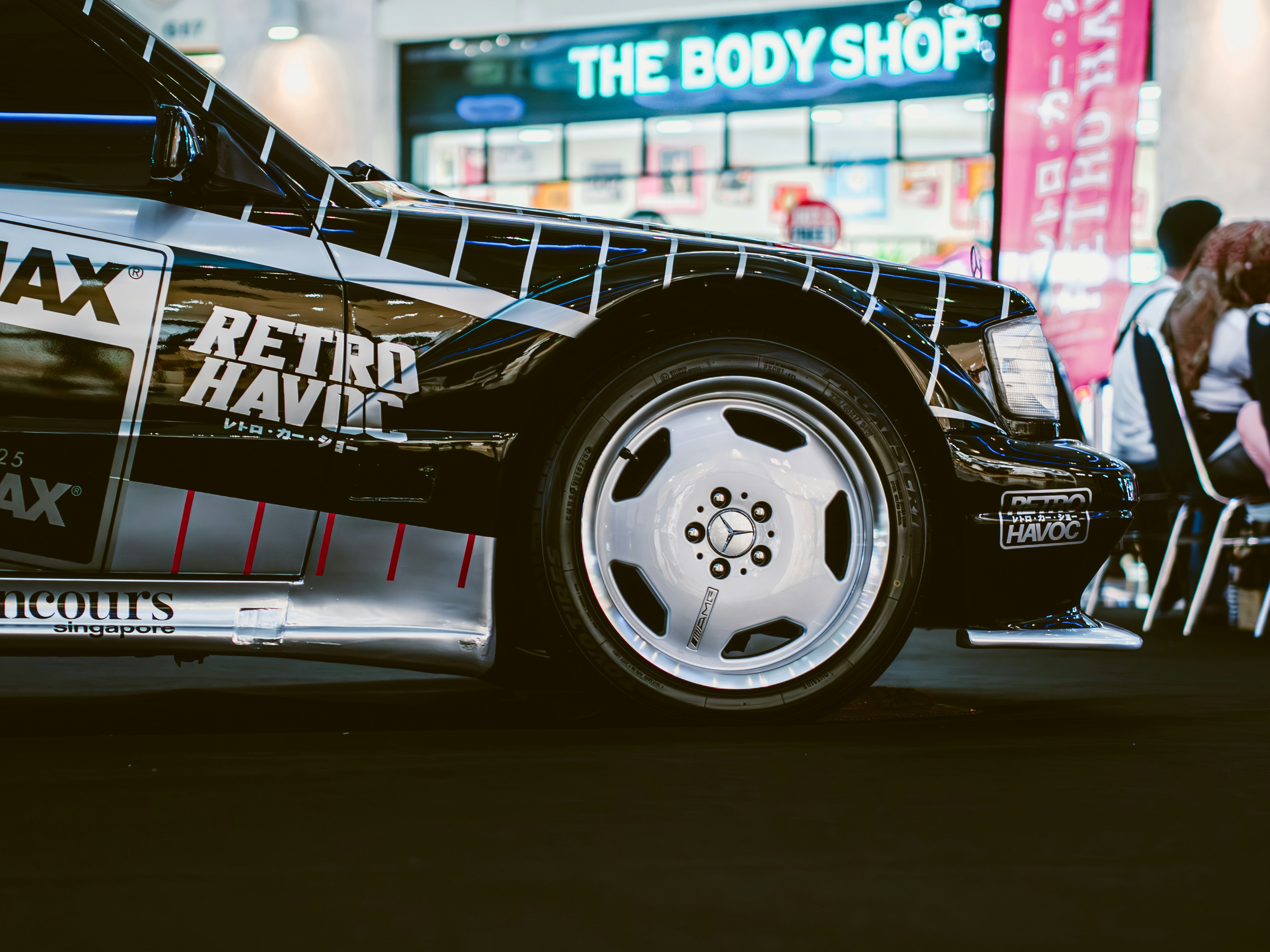 A custom car, parked in front of the body shop.
