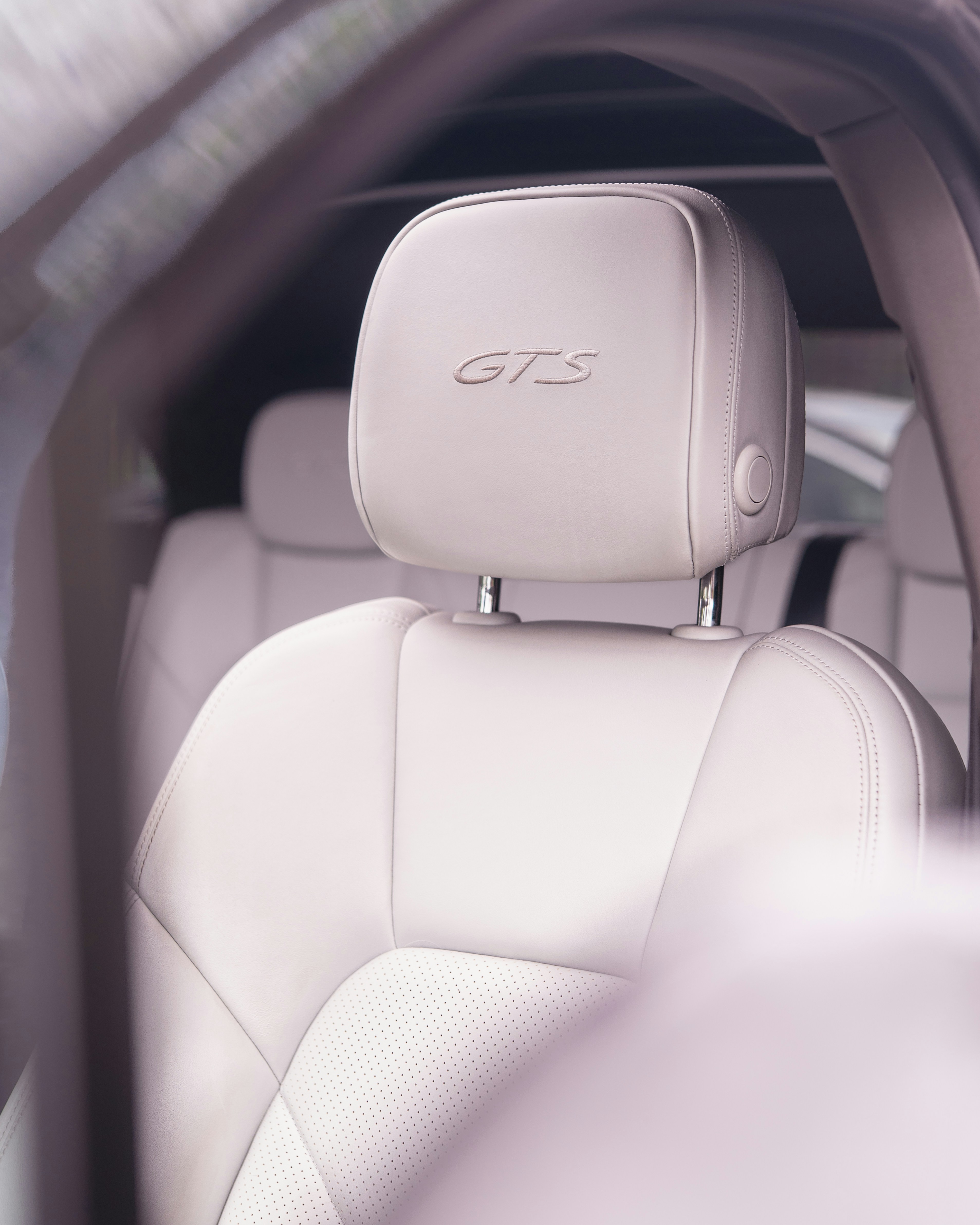 White leather car seat with "gts" embroidered.