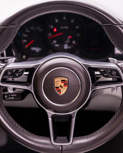 A close-up of a porsche steering wheel.