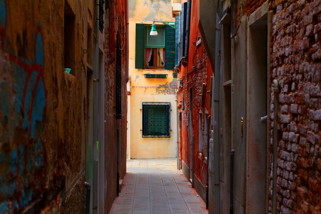 Narrow venetian alleyway with colorful walls.