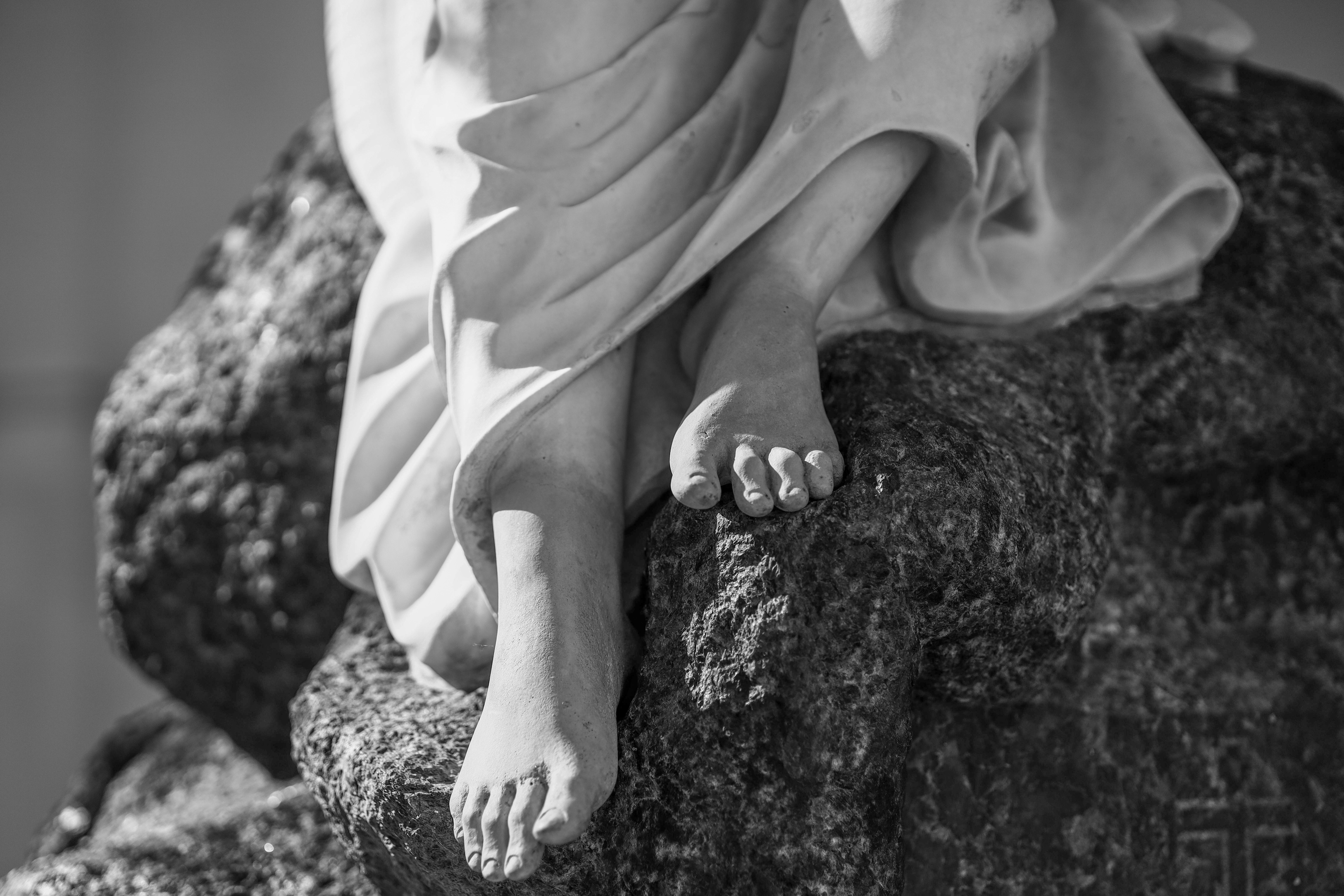 I piedi della statua poggiano su una pietra grezza.