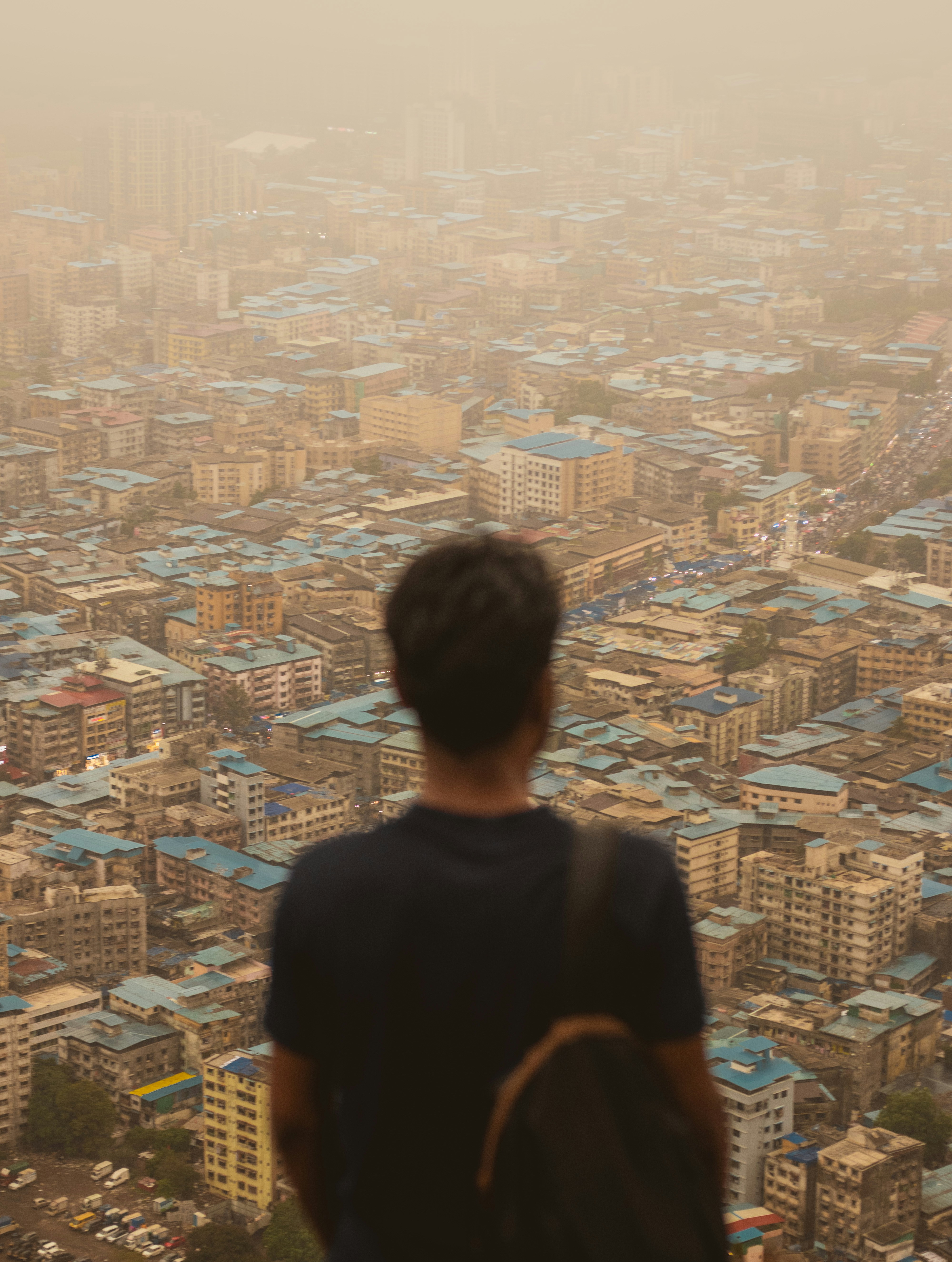 Man gazes at a smoggy cityscape.