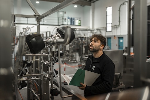 A man inspects machinery in a factory.
