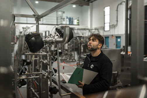 A man inspects machinery in a factory.