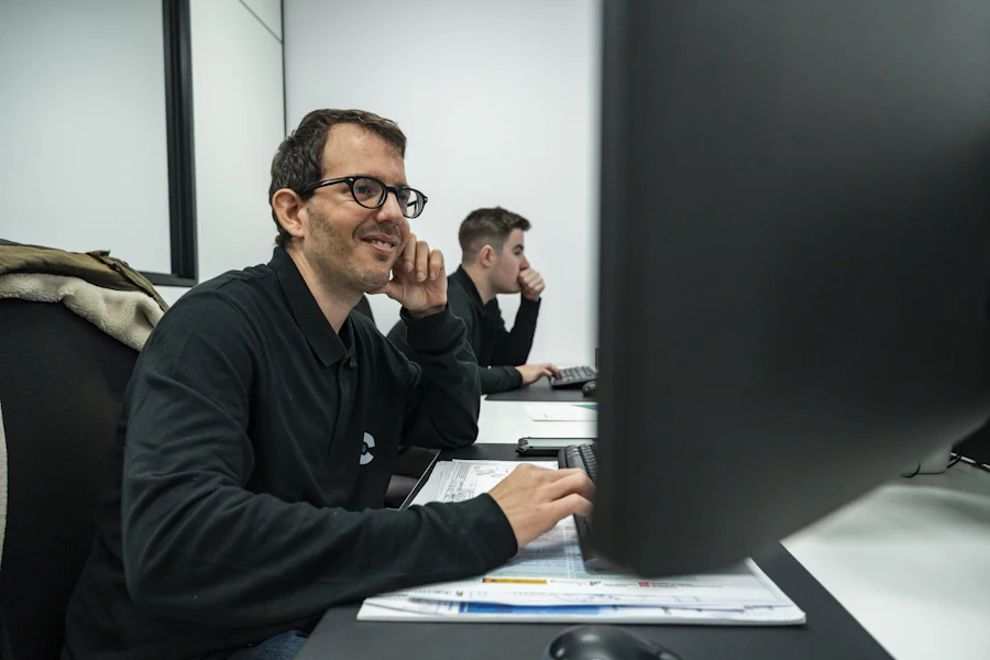 Une équipe d'ingénieurs examinant des plans techniques dans un espace de travail moderne
