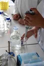 Scientist uses pipette to extract liquid in a lab.