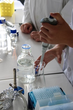 Scientist uses pipette to extract liquid in a lab.