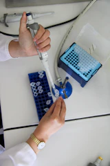 Scientist is using a pipette in a laboratory.