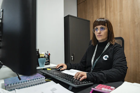 A woman is working at her office desk.