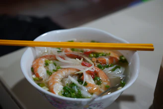 Shrimp noodle soup with chopsticks on top.