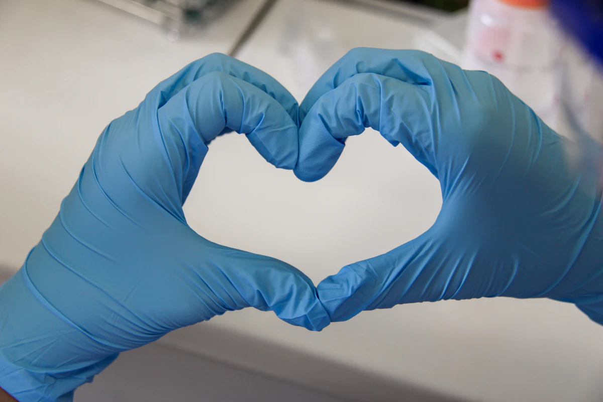 Gloved hands forming a heart shape