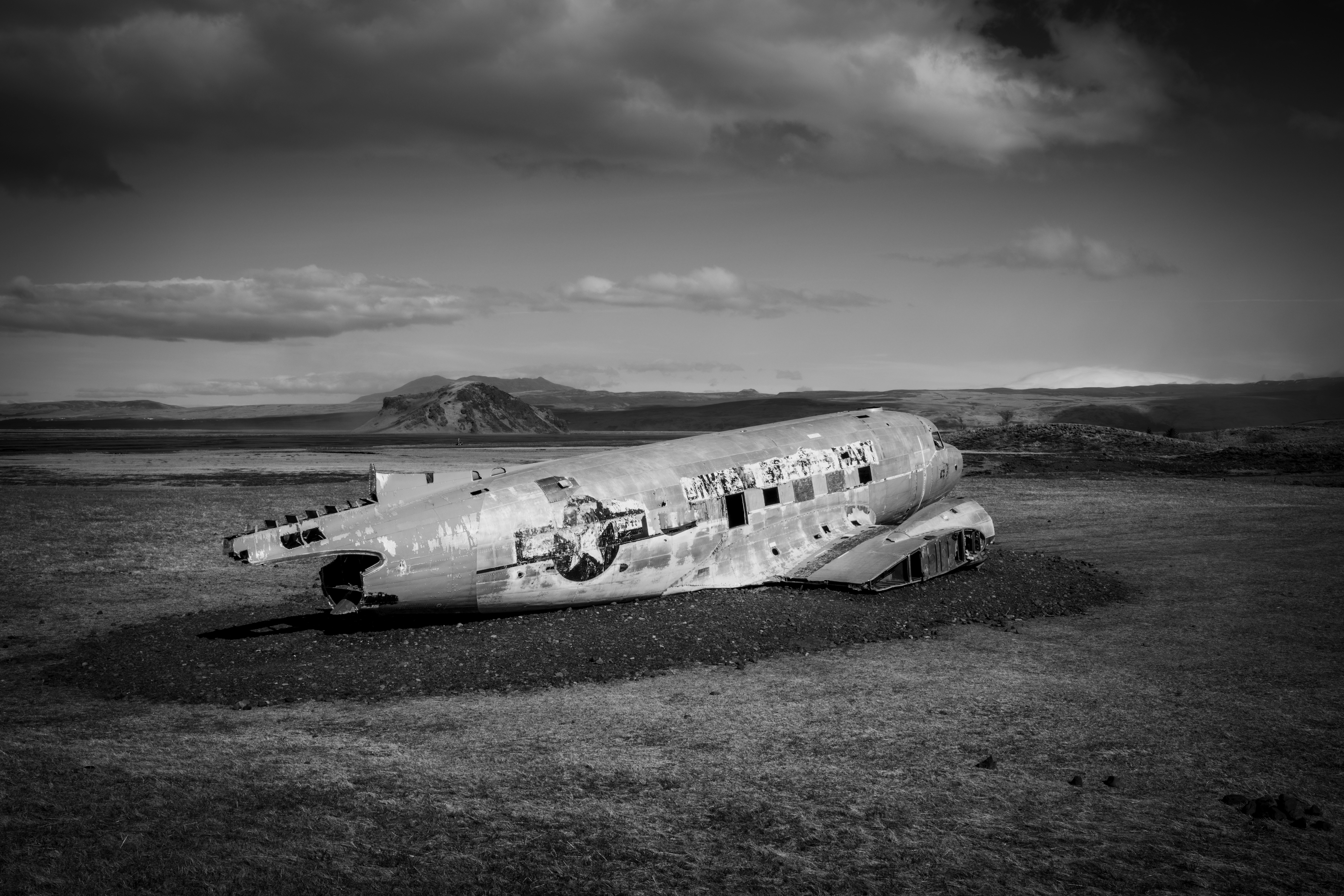 A wrecked plane sits in a grassy field.