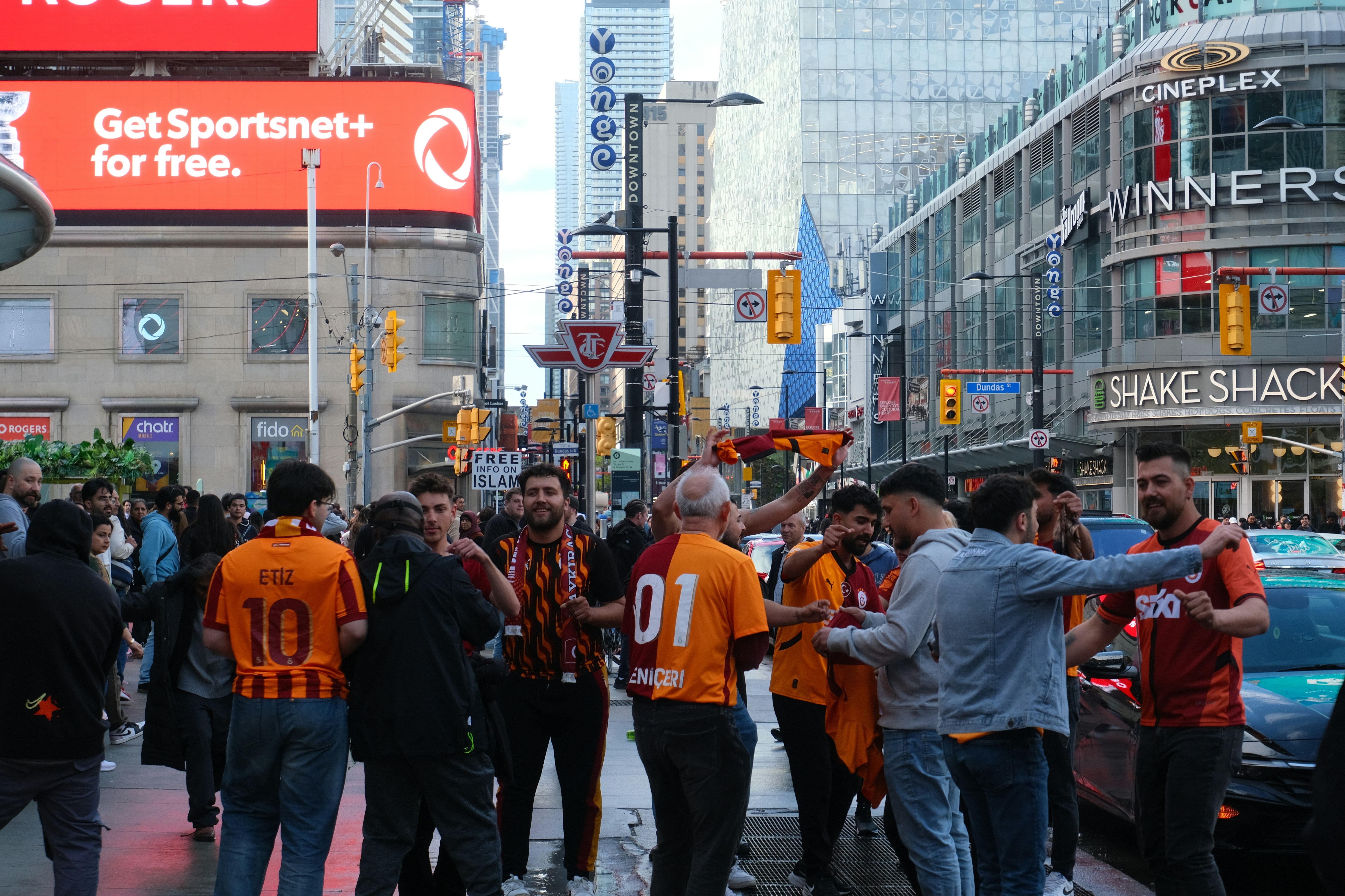 Fans celebrate on a busy city street.