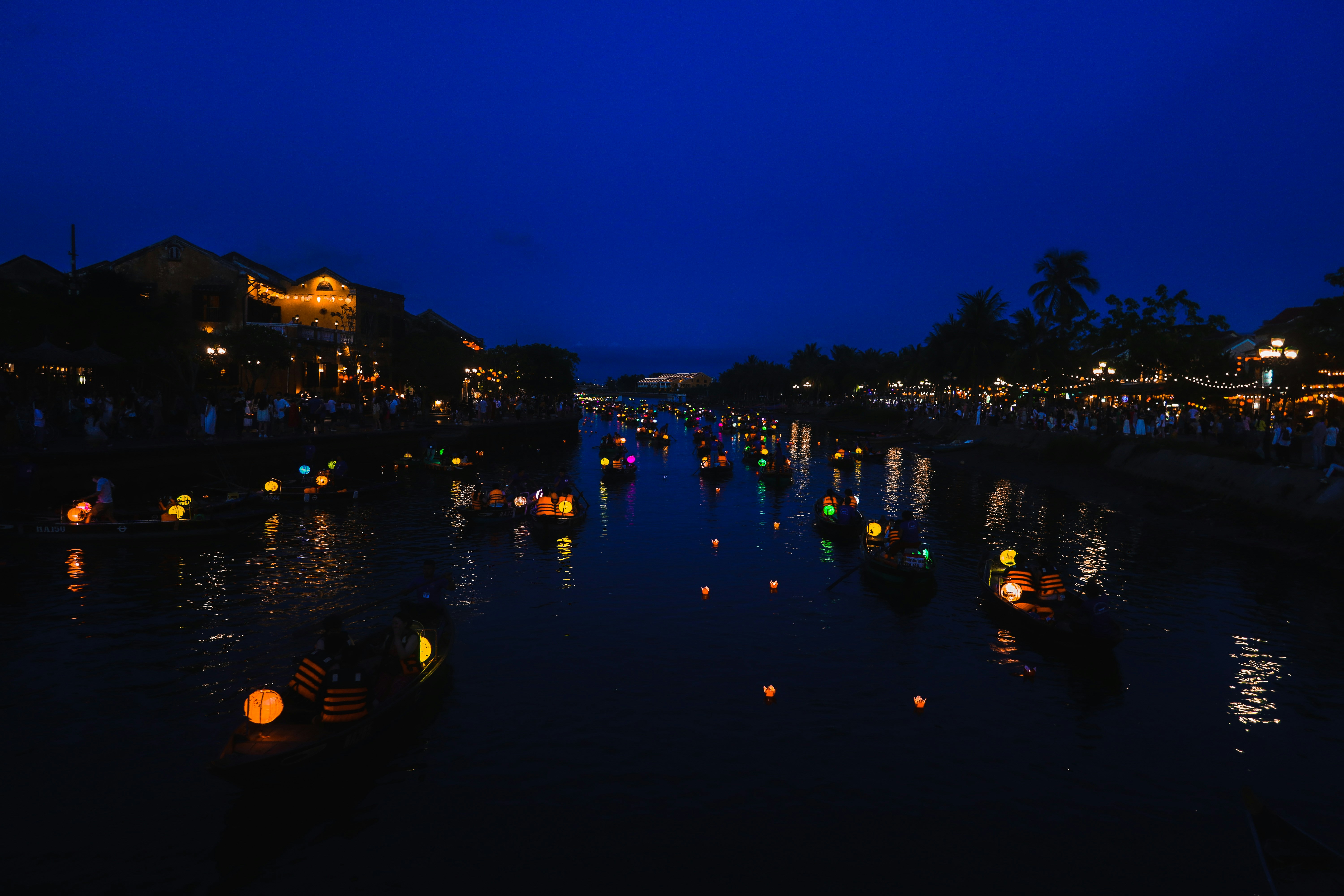 호이안 강물 위에 떠 있는 소원 등불들의 신비로운 밤 풍경, 어둠 속에서 빛나는 전통 등불들