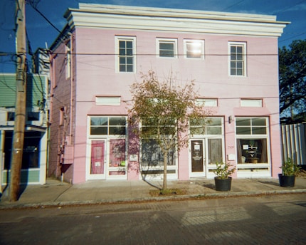 A pink building stands on a city street.
