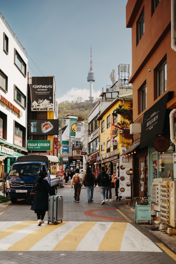 People walk a street with the n seoul tower.