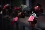 Love locks hang on a bridge railing.