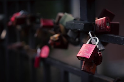 Love locks hang on a bridge railing.