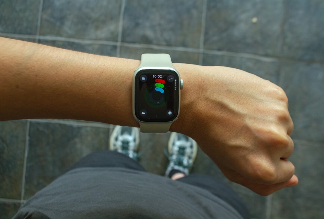 A wrist with an apple watch., Close-up of a hand with an Apple Watch and the fitness app open, with sporty sneakers in the background. A casual moment before a workout.