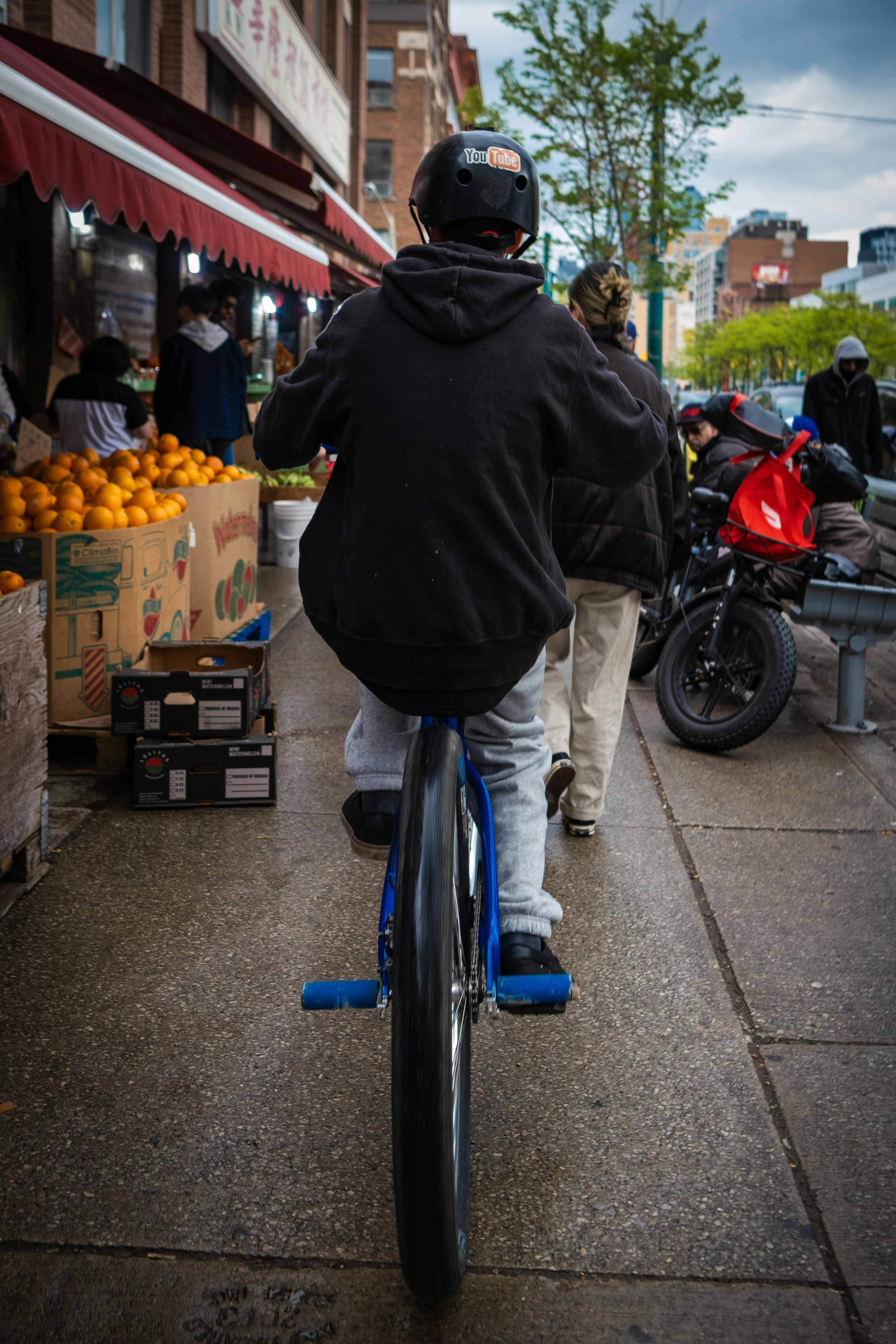 A person rides a unicycle down a city street.