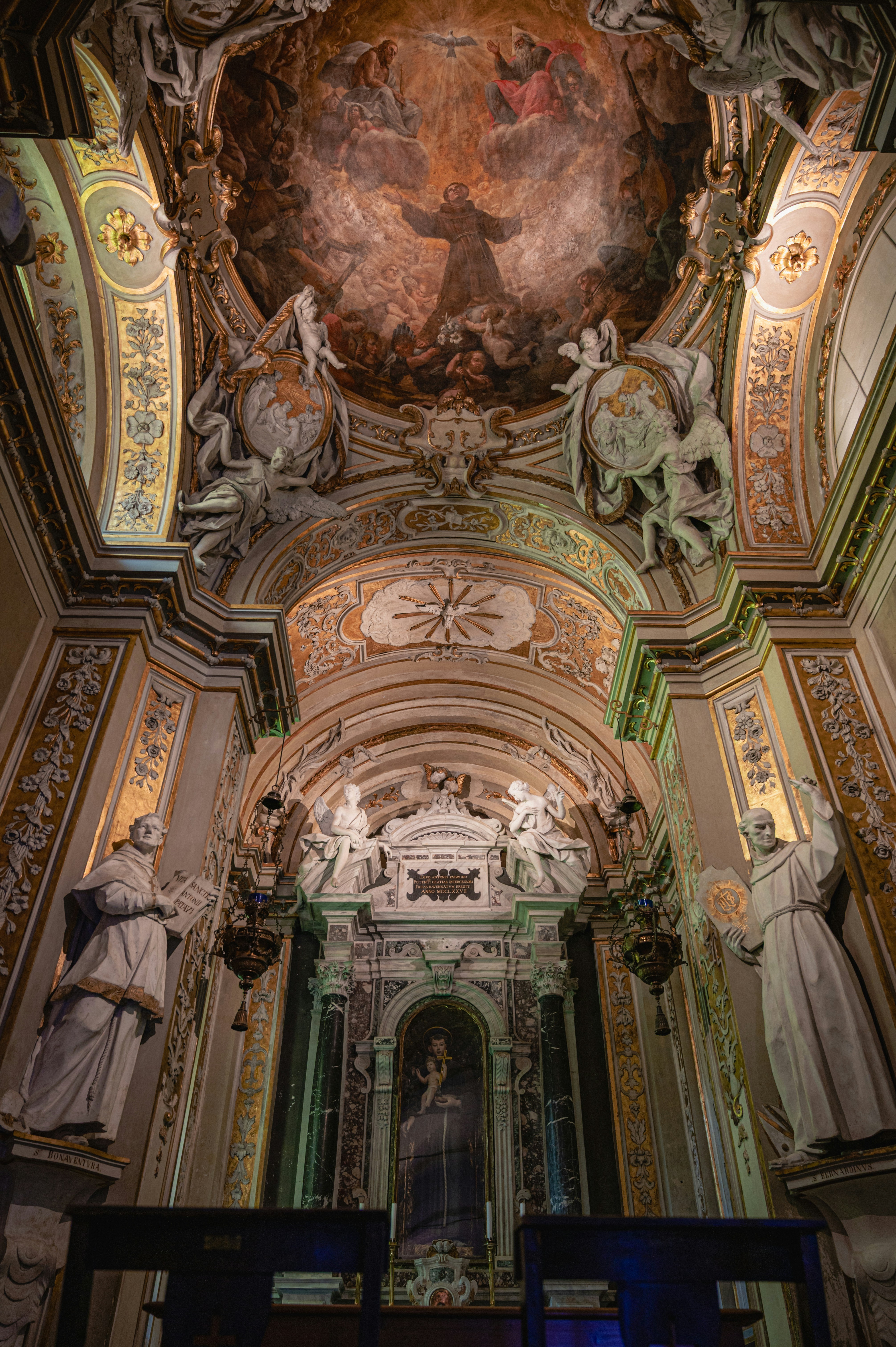 Ornate church interior featuring ceiling artwork and sculptures.