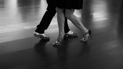 A couple dances the tango in black and white.