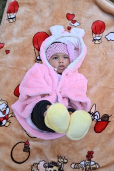 Adorable baby girl dressed in a cute pink outfit.