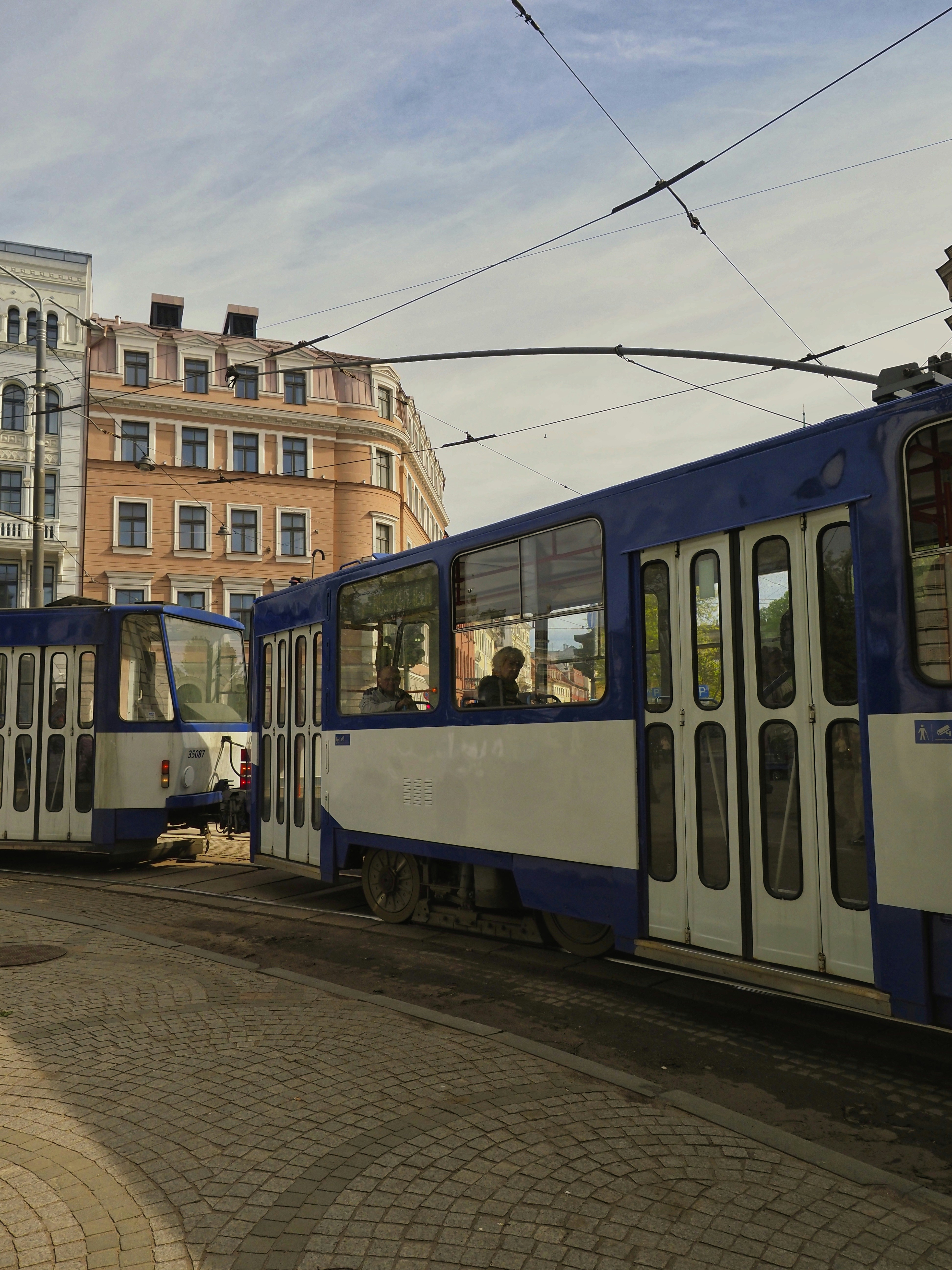 Eine blau-weiße Straßenbahn auf einer Straße in der Stadt.