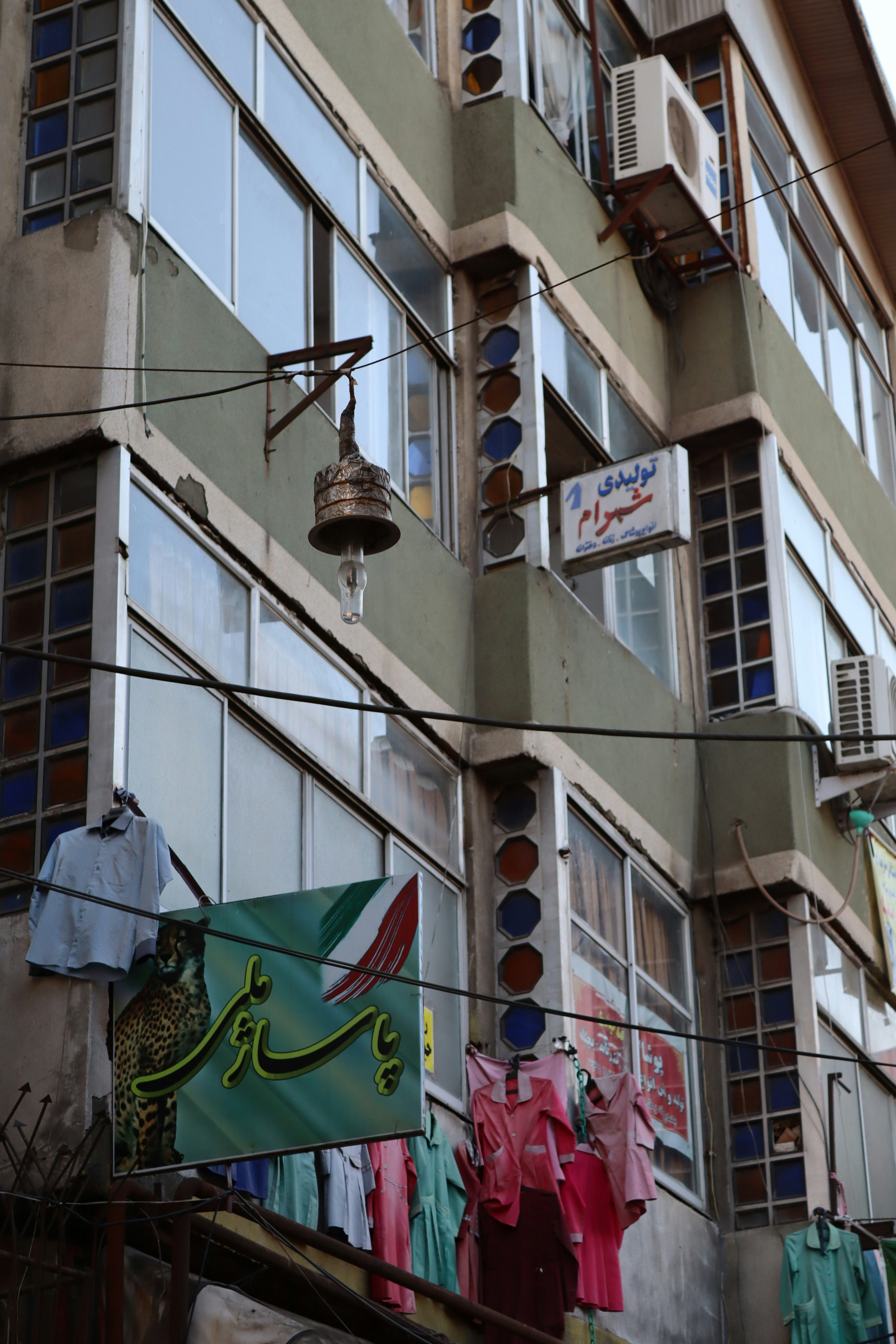 A building with windows, signs, and clothes hanging.
