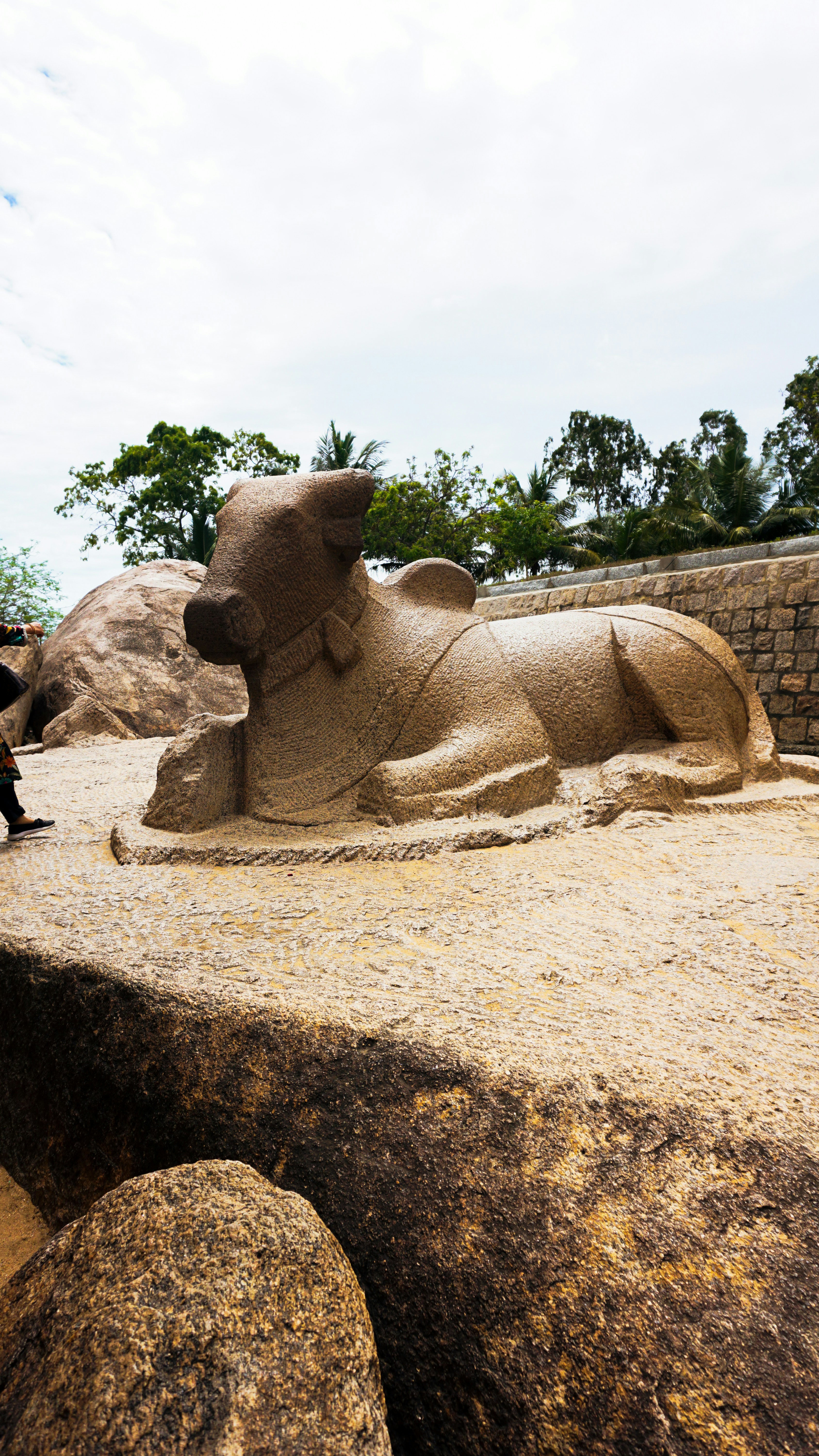 Scultura in pietra di un toro sdraiato.