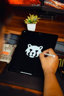 Someone is drawing a logo on their tablet