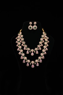 Elegant jewelry set displayed on a black mannequin.