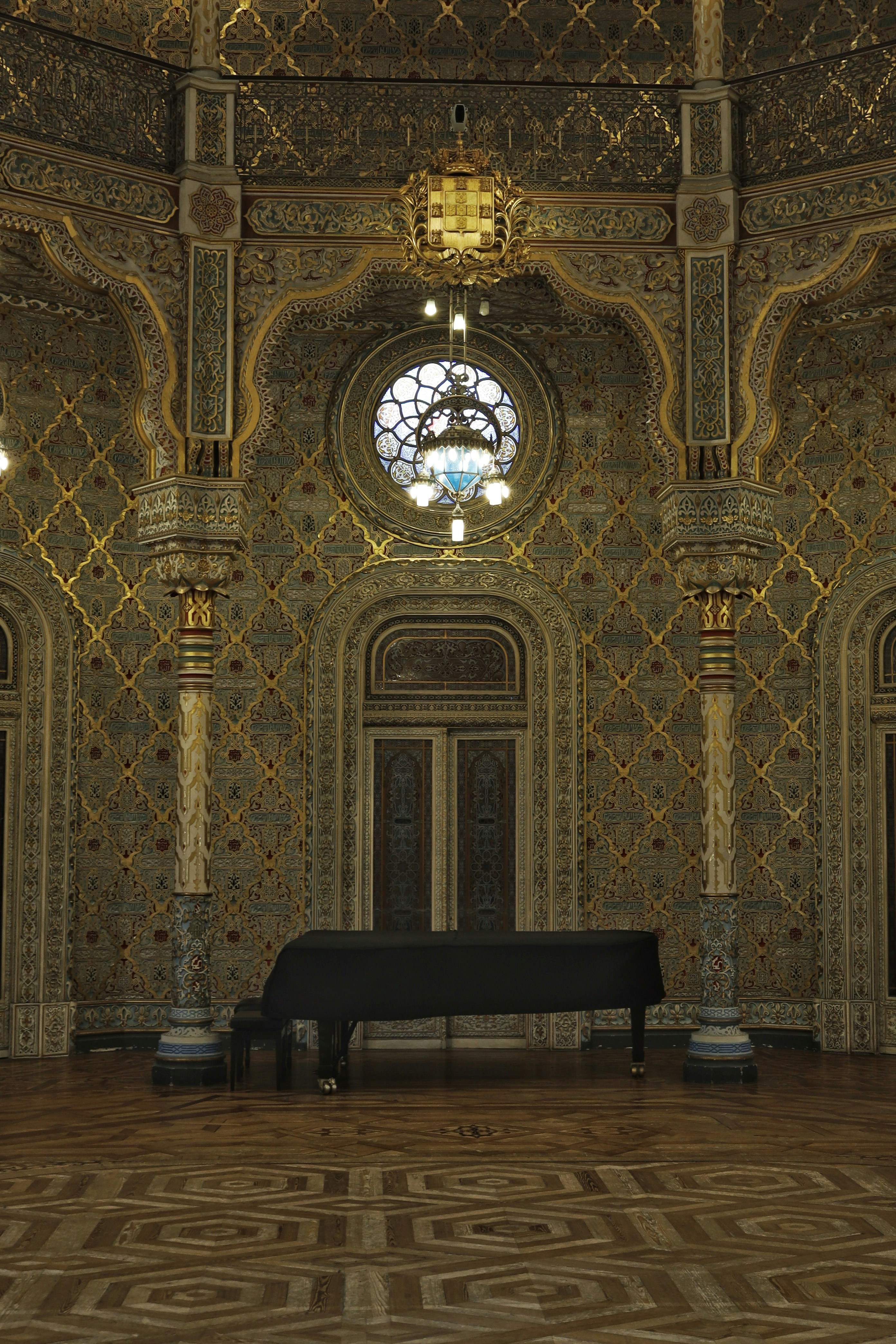 Piano stands in an ornate, gold-detailed room.