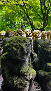 Moss-covered statues in a serene, green environment