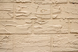 Textured beige brick wall close-up.