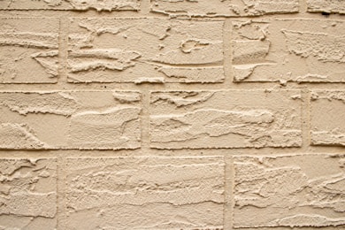 Textured beige brick wall close-up.