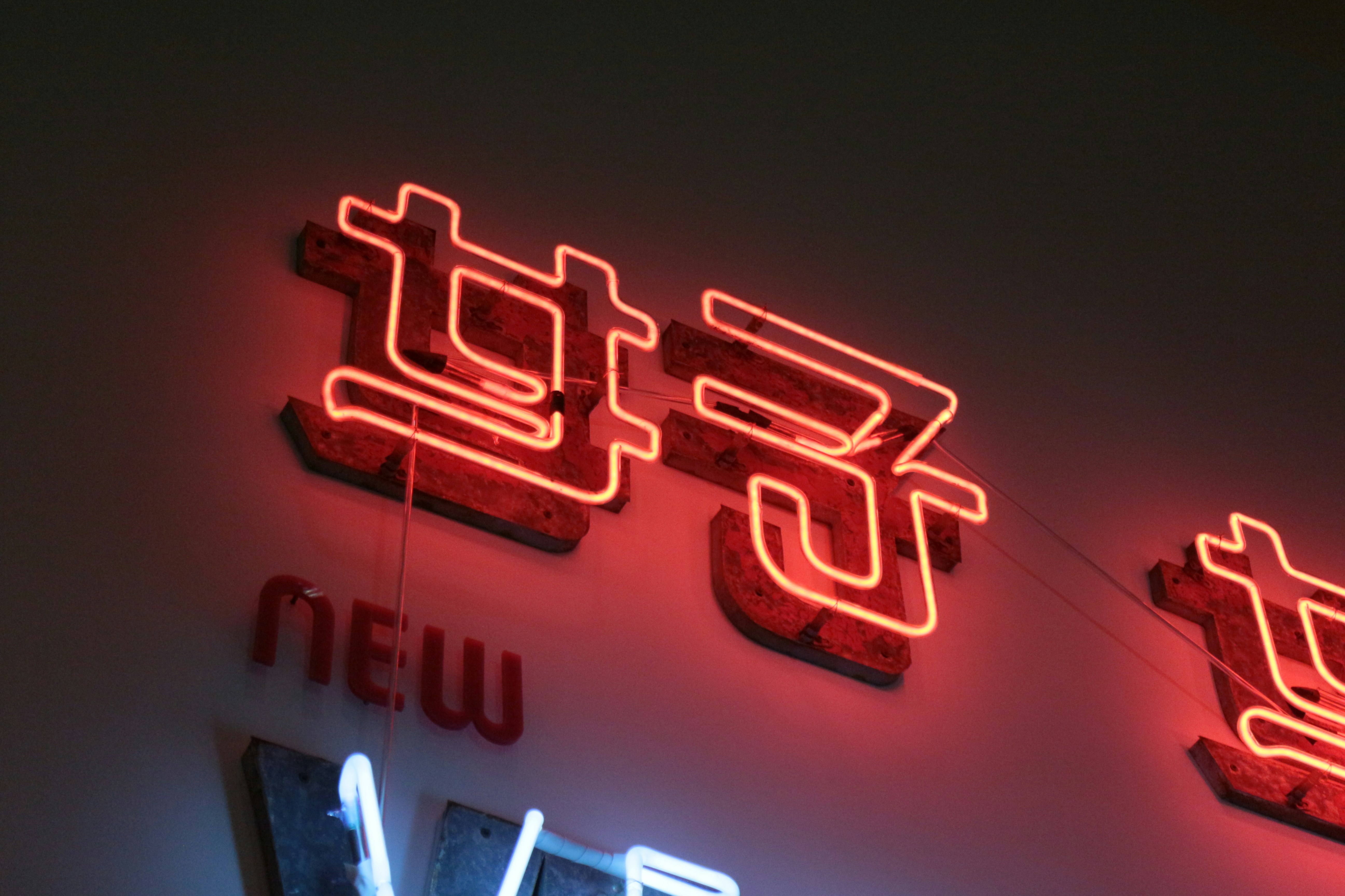 Glowing red neon lights display chinese characters., 