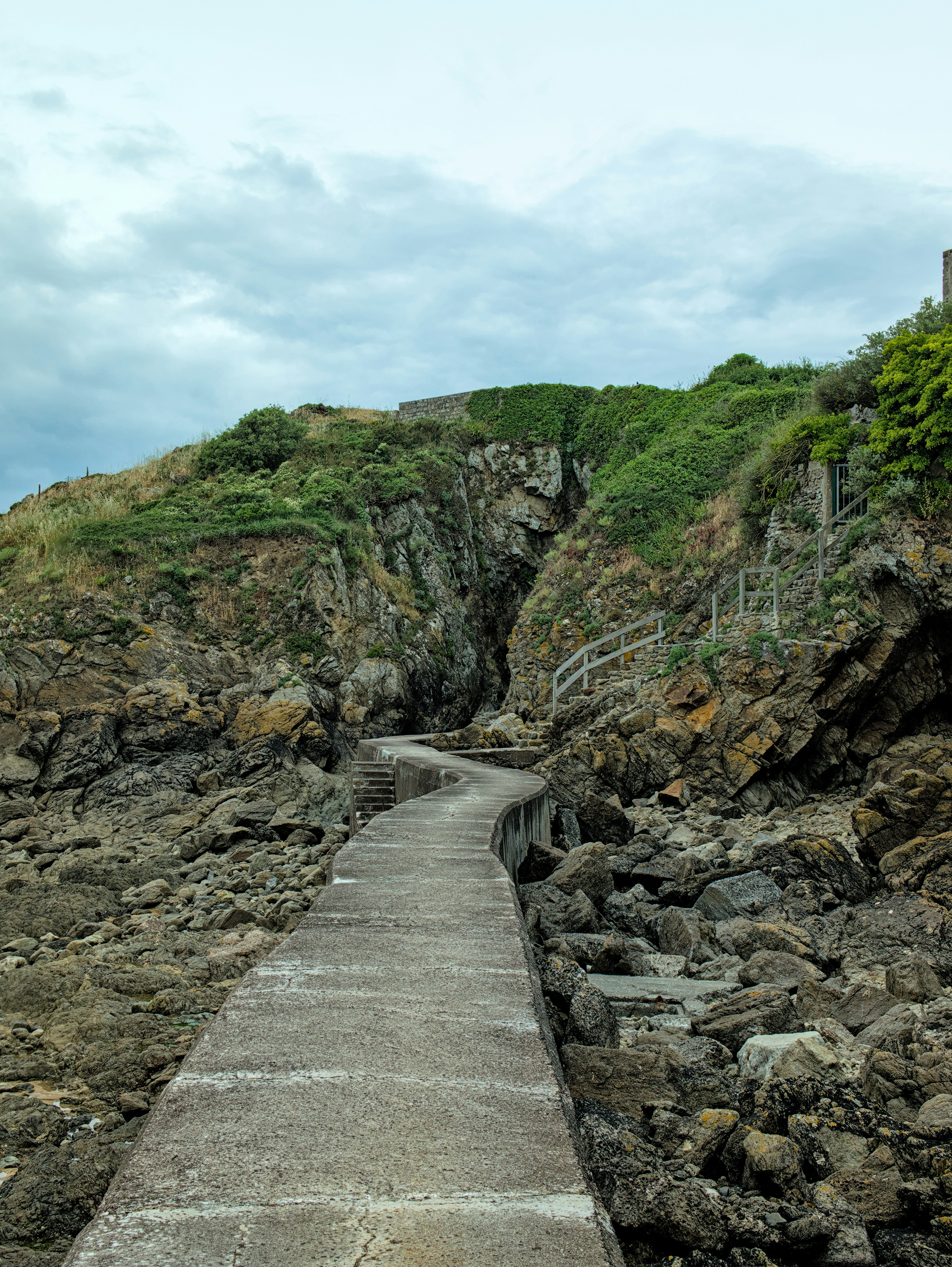 A concrete path leads up a rocky hillside.