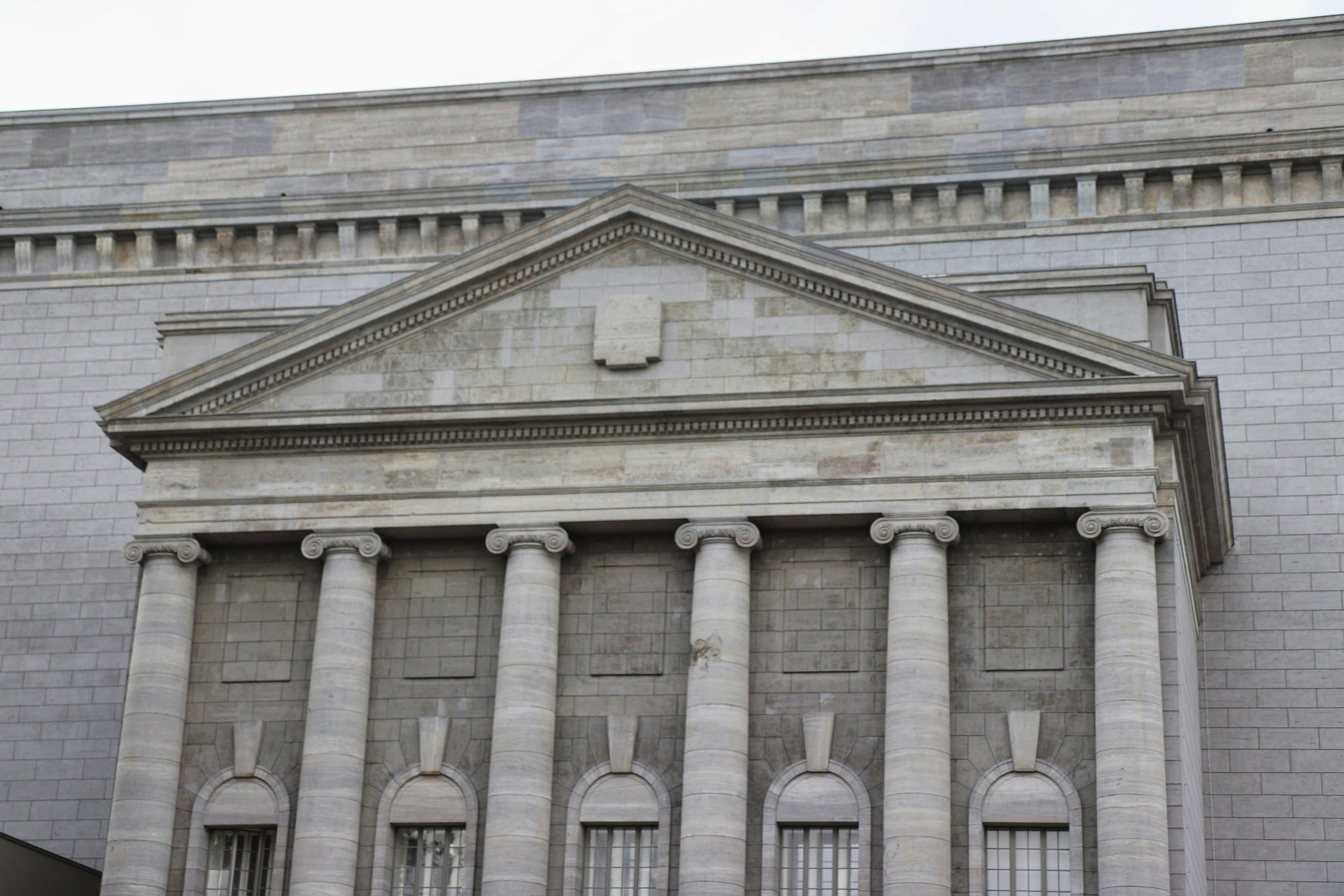 Die detaillierte architektonische Fassade eines grauen Gebäudes.