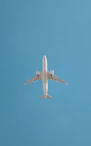 An airplane soars in the blue sky.